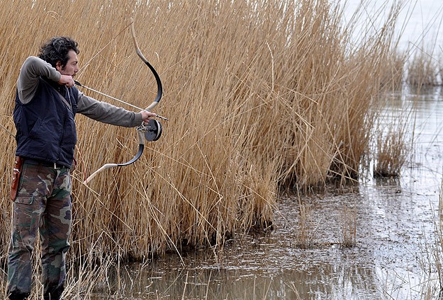 Okla balık avlıyor